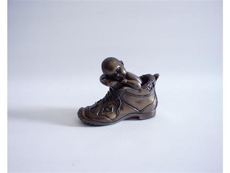 Baby in schoen bronskleurig